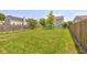 A full view of the spacious backyard with green lawn and wood fencing at 3460 Limelight Ln, Whitestown, IN 46075