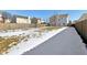 Large backyard with patchy snow, wooden fence, and neighboring houses visible at 3460 Limelight Ln, Whitestown, IN 46075