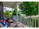 Cozy front porch with wicker seating, decorative pillows, and hanging floral arrangements at 3460 Limelight Ln, Whitestown, IN 46075