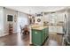 Kitchen features a teal island, white cabinets, and hardwood floors at 3460 Limelight Ln, Whitestown, IN 46075