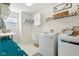 Bright laundry room with white cabinets, washer, dryer, and utility sink at 3460 Limelight Ln, Whitestown, IN 46075