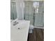 Bright bathroom with single sink vanity, glass shower, and hardwood floors at 371 Traditions Pass, Greenwood, IN 46143