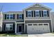 Two-story home featuring a 2-car garage, black shutters, and a landscaped front yard at 371 Traditions Pass, Greenwood, IN 46143