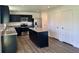 Features black cabinetry, an island, stainless steel appliances, and wood-look flooring at 371 Traditions Pass, Greenwood, IN 46143