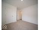 Neutral carpeted bedroom featuring two white doors and neutral walls at 6636 Sulgrove Pl, Indianapolis, IN 46221