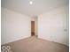 Clean, carpeted bedroom with a white door at 6636 Sulgrove Pl, Indianapolis, IN 46221