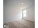 A bright bedroom with neutral carpeting and a window providing natural light creates a serene space at 6636 Sulgrove Pl, Indianapolis, IN 46221