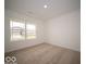 Bright, carpeted bedroom with a large window offering plenty of natural light at 6636 Sulgrove Pl, Indianapolis, IN 46221