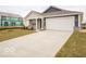 Single-story home with a two-car garage and long concrete driveway, situated on a grassy lawn at 6636 Sulgrove Pl, Indianapolis, IN 46221