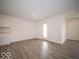 Open living area features neutral paint, luxury vinyl plank flooring, and a door to the backyard at 6636 Sulgrove Pl, Indianapolis, IN 46221