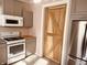 A kitchen featuring stainless steel appliances, ample counter space, and a stylish wood door at 704 S Ohio St, Sheridan, IN 46069