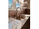Modern kitchen with granite countertops, stainless steel sink, and brushed nickel faucet under a large sunny window at 704 S Ohio St, Sheridan, IN 46069