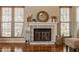 Cozy fireplace with decorative mantel, brick surround, and natural light from nearby windows at 8104 Pocket Hollow Ct, Indianapolis, IN 46256