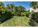 Private backyard with lush lawn, mature trees, and neatly trimmed hedges at 8526 Oakmont Ln, Indianapolis, IN 46260