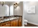 Elegant bathroom with granite countertop, wood cabinets, and art at 8526 Oakmont Ln, Indianapolis, IN 46260