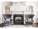 Elegant fireplace with dark granite and gray wingback chairs at 8526 Oakmont Ln, Indianapolis, IN 46260