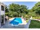 Relaxing inground pool with a slide, patio furniture, and lush landscaping at 8526 Oakmont Ln, Indianapolis, IN 46260