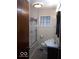 Bathroom with a shower/tub combo, a vanity, and a glass block window at 868 N Raceway Rd, Indianapolis, IN 46234