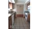 Eat-in kitchen with wood cabinets, tile floors, and white appliances at 868 N Raceway Rd, Indianapolis, IN 46234