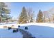 Snowy backyard with trees and walkway leading to home at 881 E 226Th St, Sheridan, IN 46069