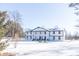 Stunning two-story home with a white and black exterior, columned entryway, and snowy landscape at 881 E 226Th St, Sheridan, IN 46069