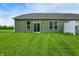 The backyard shows a well-maintained lawn, the house's rear facade, and a white privacy fence at 9711 Palermo Ave, Indianapolis, IN 46239