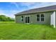 Manicured backyard features a pristine lawn, a modern home exterior, and a white fence at 9711 Palermo Ave, Indianapolis, IN 46239