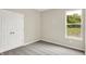 Neutral bedroom featuring a double closet, soft carpet, and a sunlit window showcasing a serene outdoor view at 9711 Palermo Ave, Indianapolis, IN 46239