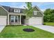 Attractive home exterior showcasing a well-manicured lawn, a two-car garage, and modern green siding at 9711 Palermo Ave, Indianapolis, IN 46239