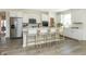 Bright kitchen featuring white cabinets, an island with seating, and hardwood floors at 9711 Palermo Ave, Indianapolis, IN 46239