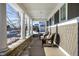 Covered porch with wicker chairs, stone wall, and winter scene at 13232 Broad St, Carmel, IN 46032