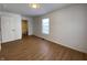 Bright bedroom with wood-look floors, neutral walls, and access to bathroom at 1608 Edgecombe Ave, Indianapolis, IN 46227