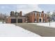 Brick home with a 2-car garage, basketball hoop, and snowy yard at 1716 Westwood Dr, Anderson, IN 46011