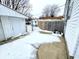 Snowy backyard with detached garage and concrete patio at 176 Monroe St, Indianapolis, IN 46229