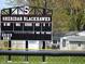 Sheridan Blackhawk's scoreboard indicating game stats in a sunny outdoor setting near trees and houses at 24415 Stout St, Sheridan, IN 46069