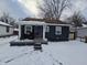 Dark blue house with white porch and snow covered yard at 3016 N Temple Ave, Indianapolis, IN 46218