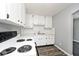 White kitchen features white appliances and wood-look vinyl flooring at 312 Green St, Plainfield, IN 46168