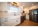 White kitchen features a farmhouse sink, stainless steel appliances, and marble backsplash at 319 W 46Th St, Indianapolis, IN 46208