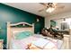 Bedroom with teal walls, ceiling fan, and queen bed at 6034 Oakbrook Ln, Indianapolis, IN 46254