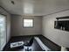 Minimalist bedroom features a large window, dark hardwood floors, and neutral walls at 604 Gooseberry Ln, Greenwood, IN 46143