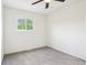 Empty carpeted bedroom with ceiling fan, neutral paint and a window with bright sunlight at 6327 E 52Nd Pl, Indianapolis, IN 46226