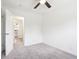 Empty bedroom showcasing a doorway to an attached bathroom, neutral walls, carpet and a ceiling fan at 6327 E 52Nd Pl, Indianapolis, IN 46226