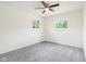 Carpeted empty bedroom with ceiling fan and neutral colors with natural light from two windows at 6327 E 52Nd Pl, Indianapolis, IN 46226