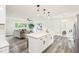 Updated kitchen with white cabinets, an island with bar seating, and an open layout to the living area at 6327 E 52Nd Pl, Indianapolis, IN 46226