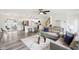 Open-concept living area with modern gray furniture, updated flooring, and a view into the bright kitchen at 6327 E 52Nd Pl, Indianapolis, IN 46226