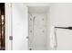 Bright, white-tiled shower with built-in niches, towel rack, and door ajar at 6327 E 52Nd Pl, Indianapolis, IN 46226