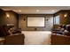 Basement home theater room with comfortable leather recliners and a large screen at 12596 Autumn Gate Way, Carmel, IN 46033
