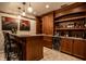 Finished basement bar with wooden bar, wine fridge, and decorative glass pendant lights at 12596 Autumn Gate Way, Carmel, IN 46033
