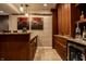 Finished basement bar with wooden bar, cabinetry, wine fridge, and travertine tile flooring at 12596 Autumn Gate Way, Carmel, IN 46033