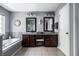 Well-lit bathroom features a double vanity, tub, dark wood cabinets, and stylish mirrors at 12596 Autumn Gate Way, Carmel, IN 46033